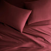 ruby red bamboo bed sheets with sateen weave from the Signature Collection, overhead view highlighting smooth texture and matching pillowcases