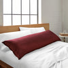 ruby red bamboo body pillow from the Signature Collection, shown on a ruby red bed in a bright modern bedroom with natural light and wood headboard