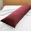 ruby red bamboo body pillow with sateen weave from the Signature Collection, displayed on a ruby red bed for contrast and texture focus