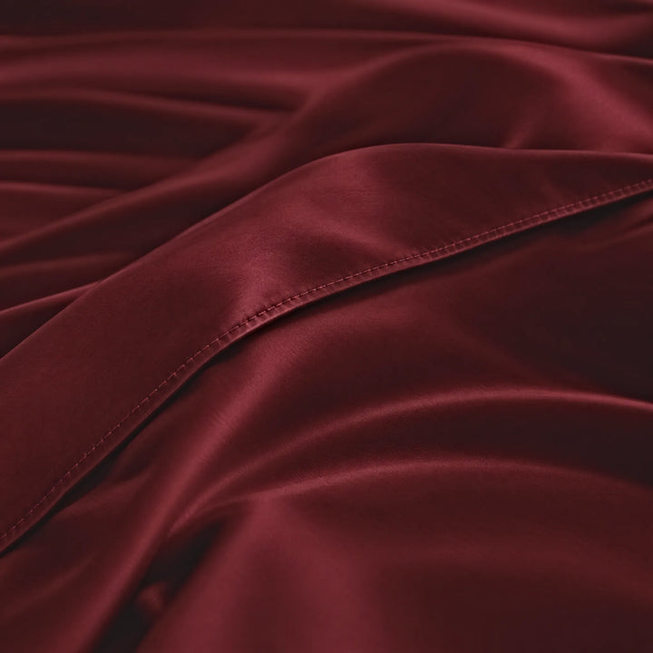 Ruby Red bamboo viscose sateen body pillowcase macro close-up of silky sateen folds and stitched envelope closure
