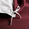ruby red bamboo duvet cover from the Signature Collection, close-up of internal corner tie securing ruby red insert with smooth sateen fabric