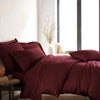 modern bedroom with ruby red bamboo sateen sheet set on king bed, featuring matching pillowcases and duvet, styled with natural light and minimal decor