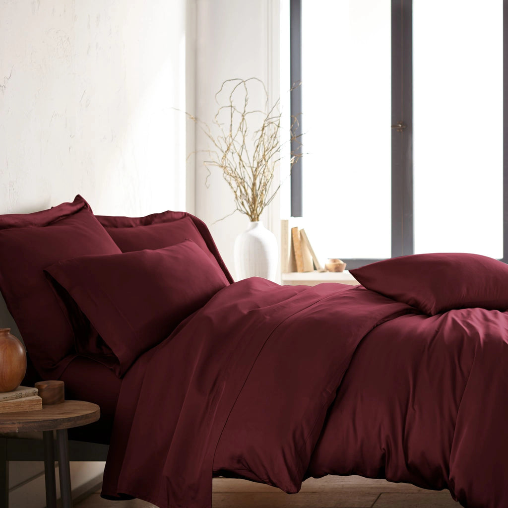 modern bedroom with ruby red bamboo sateen sheet set on king bed, featuring matching pillowcases and duvet, styled with natural light and minimal decor