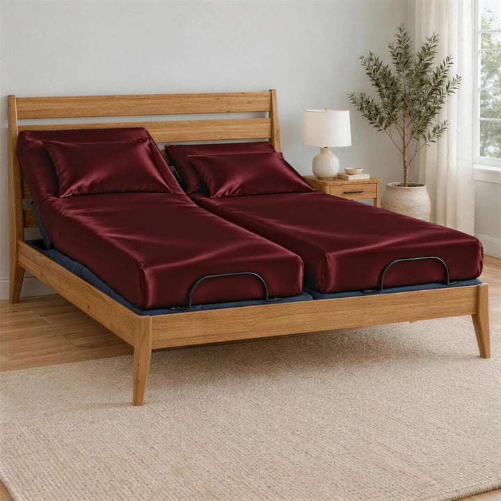 Ruby Red bamboo viscose Signature fitted sheets on a Split King bed: two separate mattresses, each with its own fitted sheet, on an adjustable base in a bamboo frame, left side raised