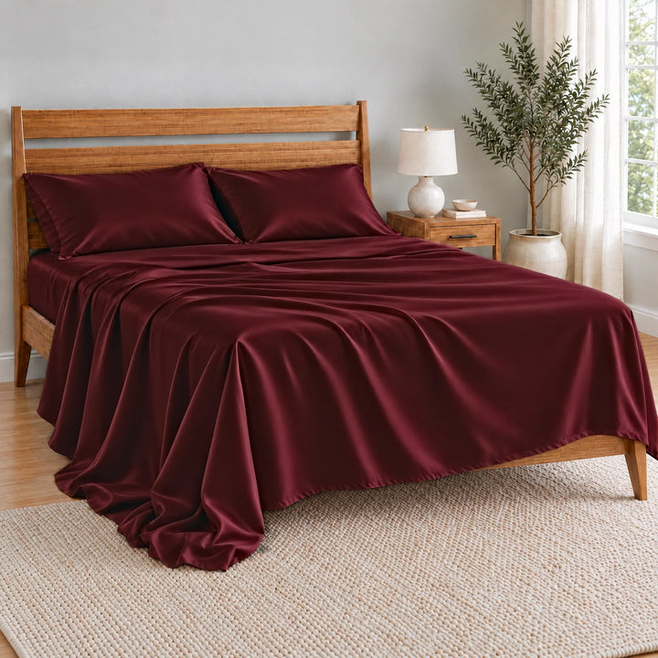 Ruby Red bamboo viscose flat sheet oversized and relaxed, spilling over the side of the bed in soft folds