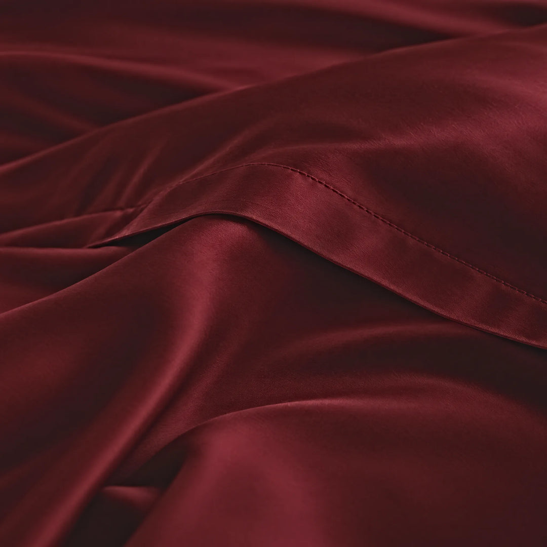 Ruby Red bamboo viscose sateen lumbar pillowcase macro close-up of silky sateen folds and stitched hem