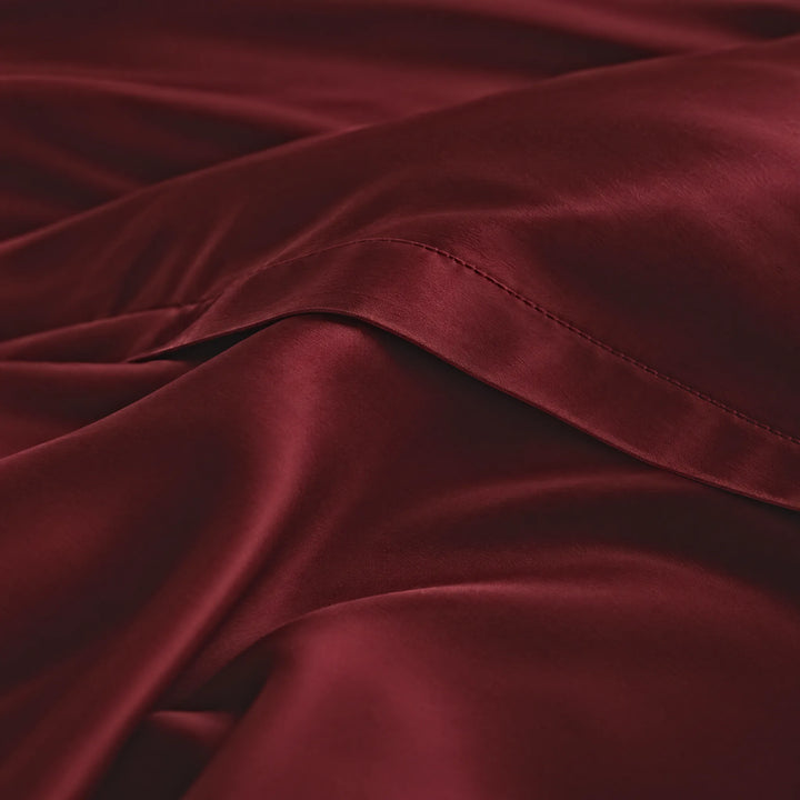 Ruby Red bamboo viscose sateen lumbar pillowcase macro close-up of silky sateen folds and stitched hem