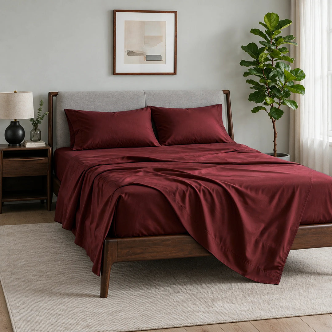 ruby red bamboo viscose sateen sheet set, three-quarter view with the flat sheet pulled back over the fitted sheet