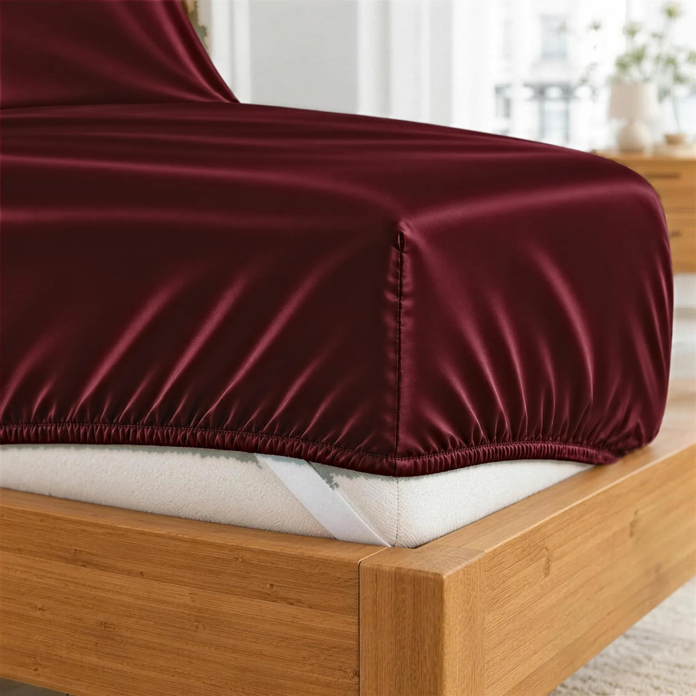 Ruby Red bamboo viscose fitted sheet deep-pocket corner close-up with all-around elastic and a corner strap, from the sheet set