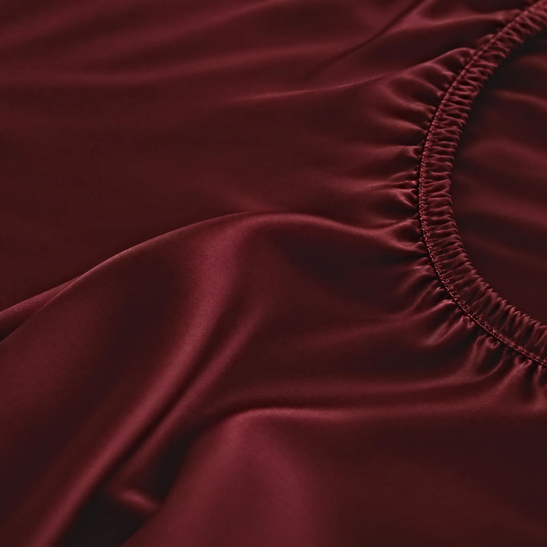 Ruby Red bamboo viscose fitted sheet stitched elastic hem macro close-up of smooth silky sateen, from the sheet set