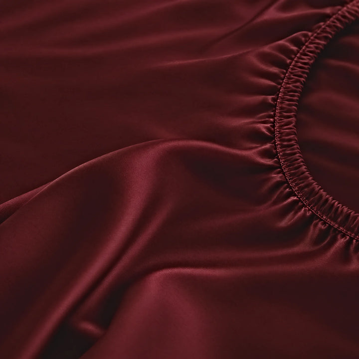 Ruby Red bamboo viscose fitted sheet stitched elastic hem macro close-up of smooth silky sateen, from the sheet set