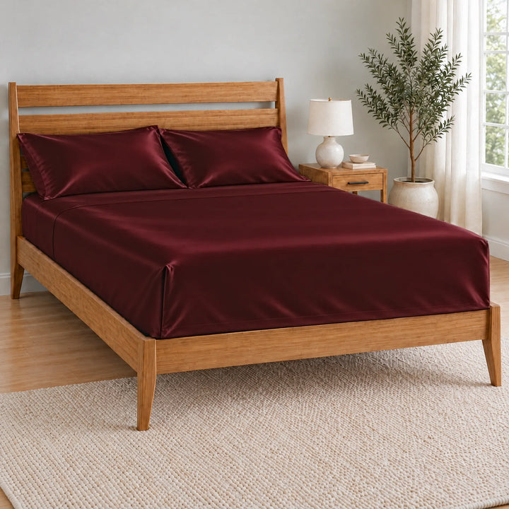 Ruby Red bamboo viscose flat sheet with a tucked hospital corner on a made bed, from the sheet set