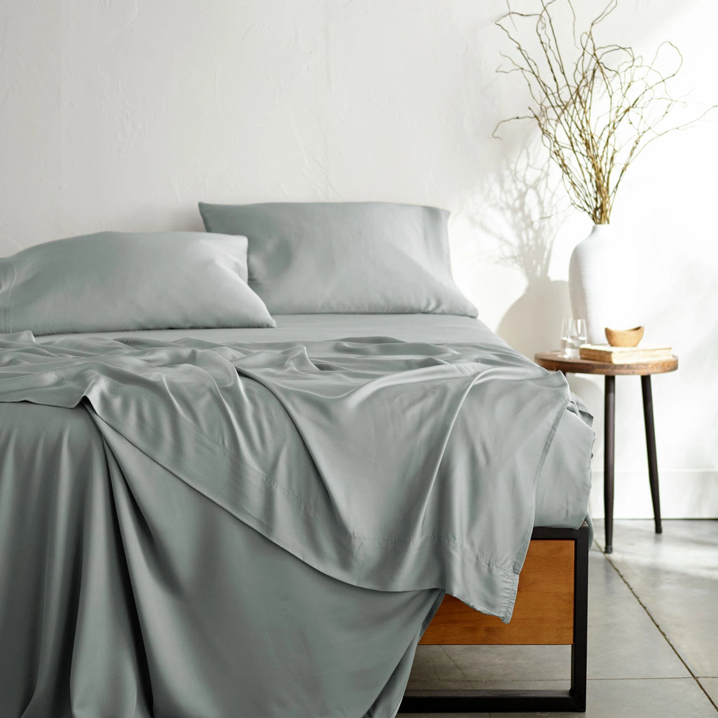 silver bamboo bed sheets with sateen weave from the Signature Collection, shown from the foot of the bed with a draped flat sheet and matching pillowcases