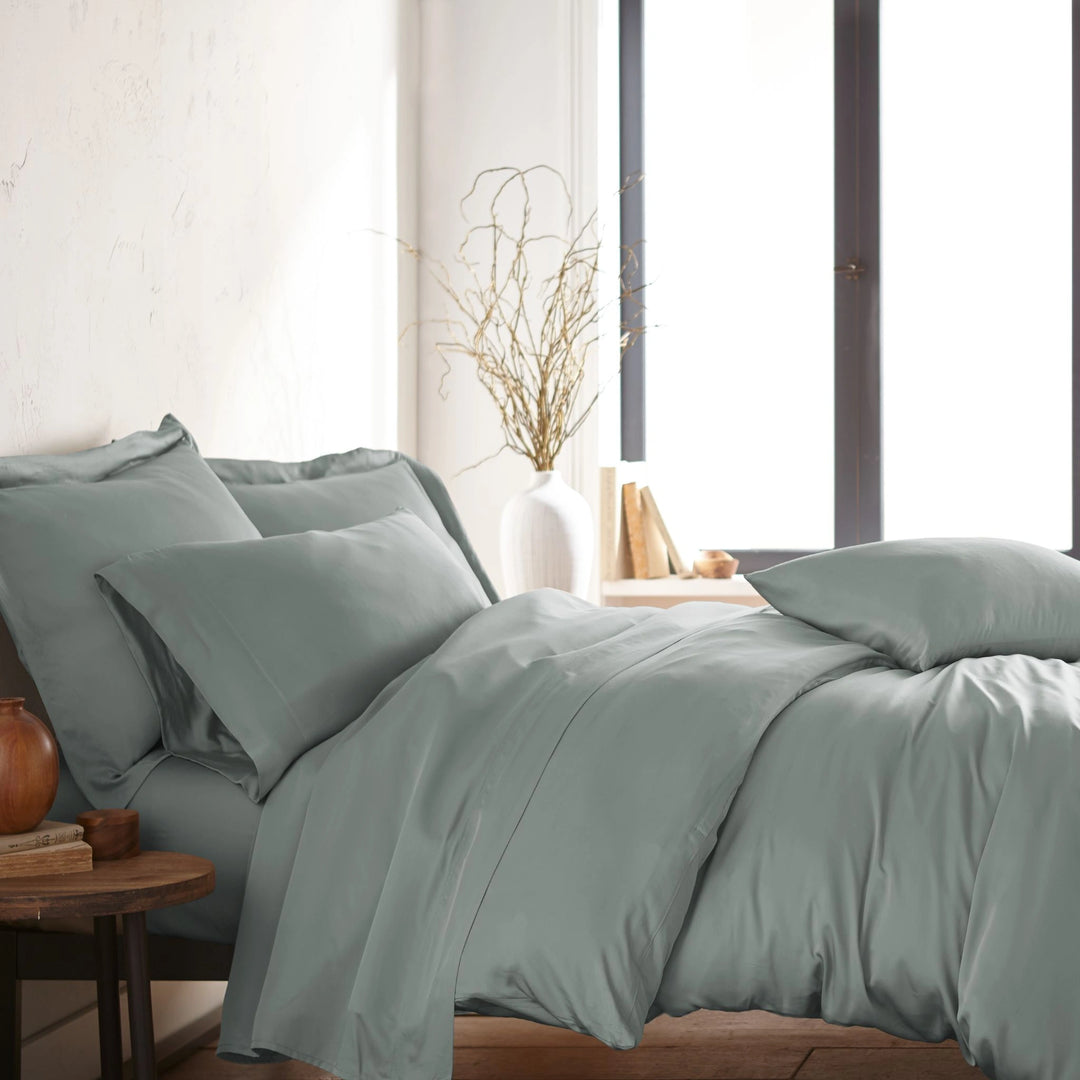 modern bedroom with silver bamboo sateen sheet set on king bed, featuring matching pillowcases and duvet, styled with natural light and minimal decor