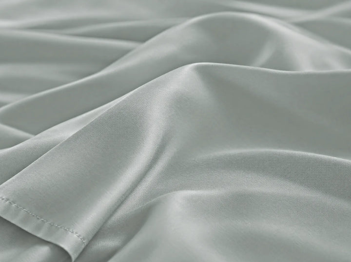 Silver bamboo viscose flat sheet macro close-up of smooth silky sateen folds and a stitched hem