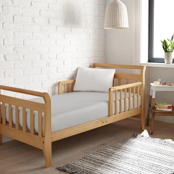 silver bamboo toddler fitted sheet from the Signature Collection, styled in a wooden toddler bed with white pillow and modern nursery decor