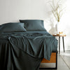 slate bamboo bed sheets with sateen weave from the Signature Collection, shown from the foot of the bed with a draped flat sheet and matching pillowcases