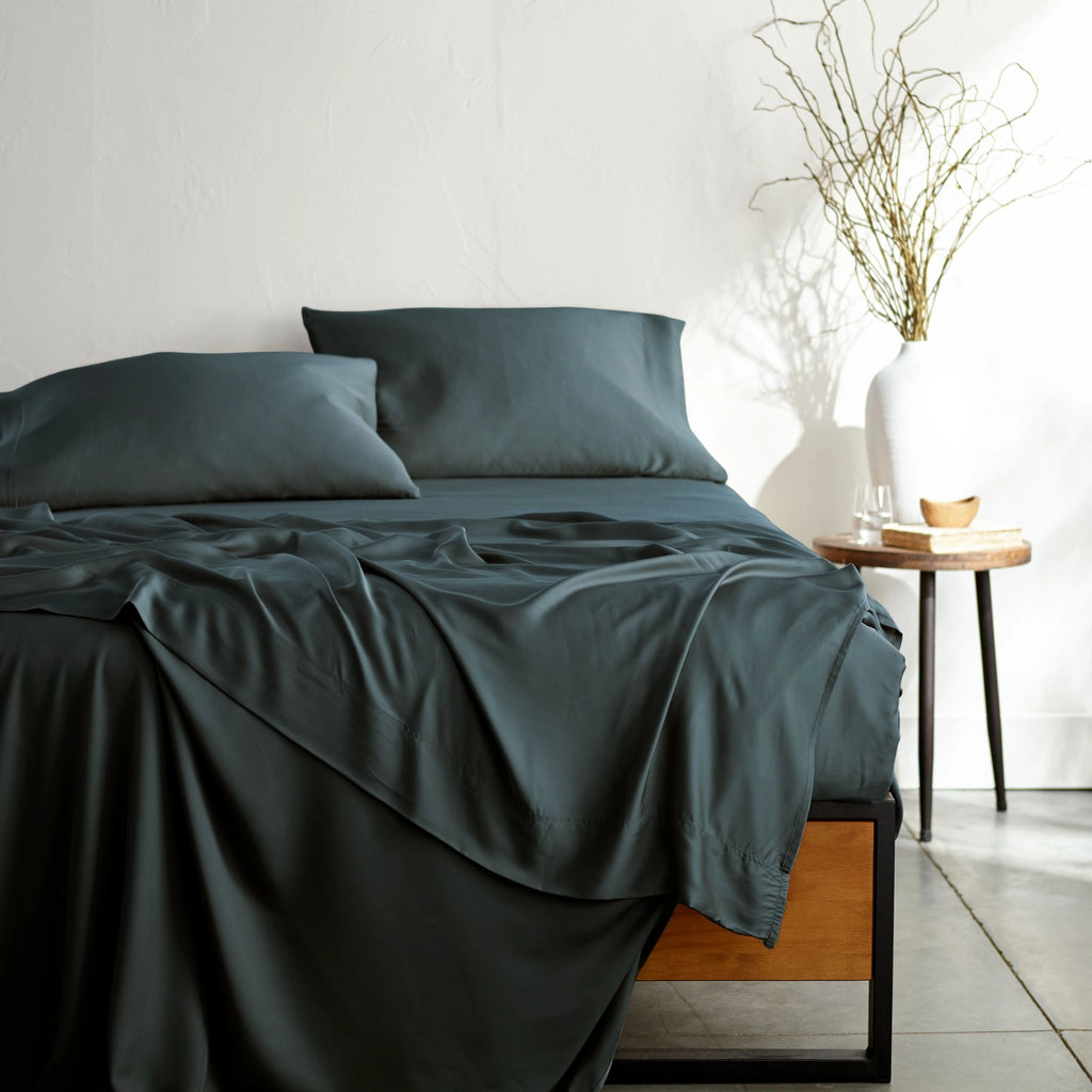 slate bamboo bed sheets with sateen weave from the Signature Collection, shown from the foot of the bed with a draped flat sheet and matching pillowcases