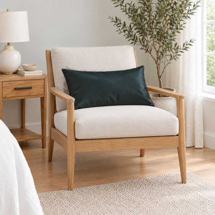 Slate bamboo viscose sateen lumbar pillowcase on a light oak armchair beside a nightstand and olive tree