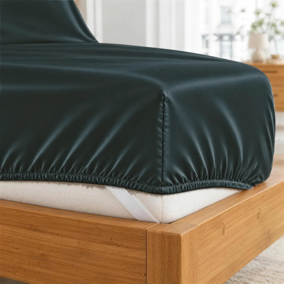 Slate bamboo viscose fitted sheet deep-pocket corner close-up with all-around elastic and a corner strap, from the sheet set