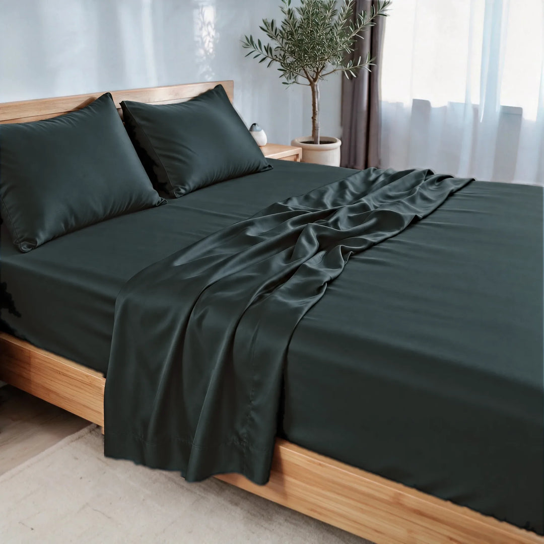 Slate bamboo viscose sateen sheet set, three-quarter view with the flat sheet pulled back over the fitted sheet