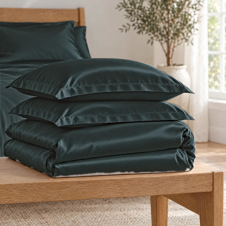 Slate bamboo viscose Signature duvet cover and two shams, neatly folded in a stack on an oak bench