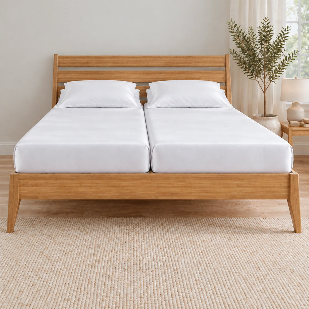 Foot of a Split King bed showing two separate mattresses, each with its own white bamboo viscose fitted sheet