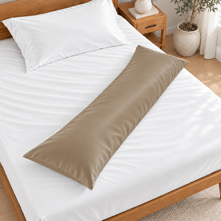 Taupe bamboo viscose sateen body pillowcase lying diagonally across a made bed, overhead view in a bright bedroom with a honey bamboo bed