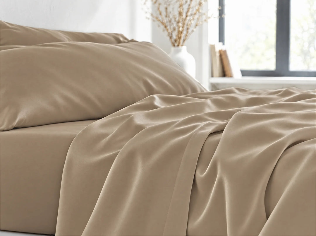 Taupe bamboo viscose flat sheet close-up billowing over the mattress edge in relaxed sateen folds