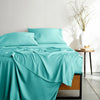 tiffany blue bamboo bed sheets with sateen weave from the Signature Collection, shown from the foot of the bed with a draped flat sheet and matching pillowcases
