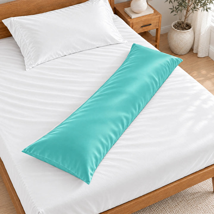 Tiffany Blue bamboo viscose sateen body pillowcase lying diagonally across a made bed, overhead view in a bright bedroom with a honey bamboo bed