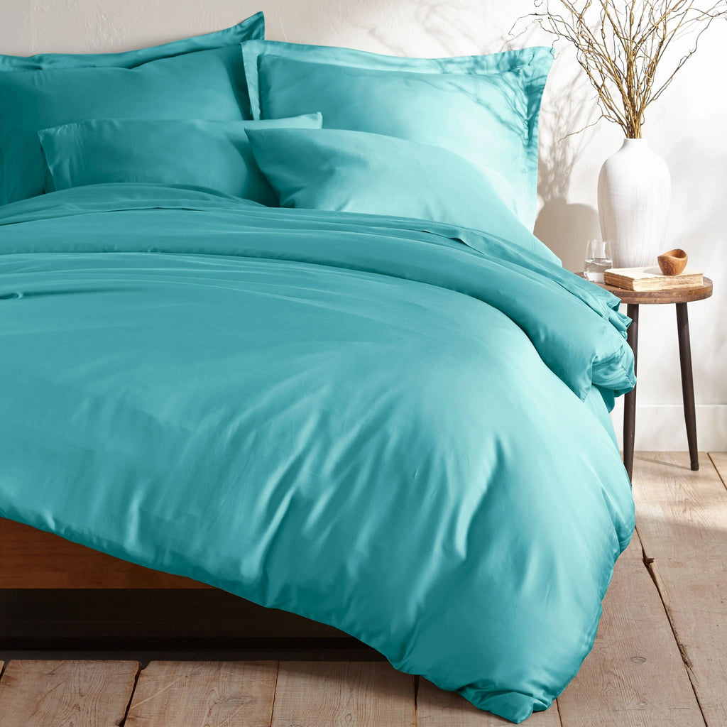 tiffany blue bamboo sateen bedding set with pillowcases and duvet on king bed, styled in minimal bedroom with rustic wood floors and ceramic vase decor