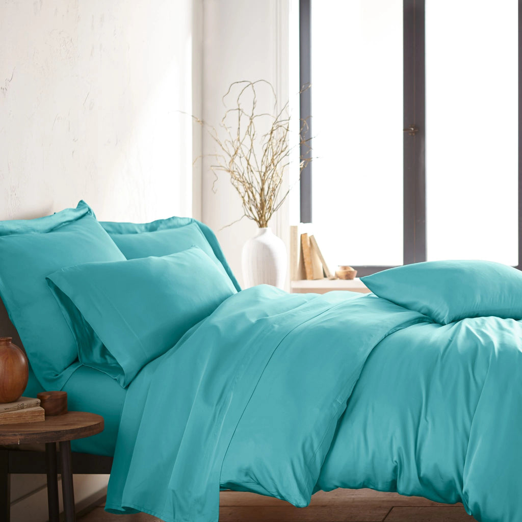 modern bedroom with tiffany blue bamboo sateen sheet set on king bed, featuring matching pillowcases and duvet, styled with natural light and minimal decor