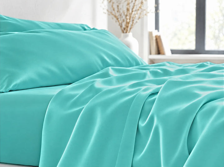 Tiffany Blue bamboo viscose flat sheet close-up billowing over the mattress edge in relaxed sateen folds