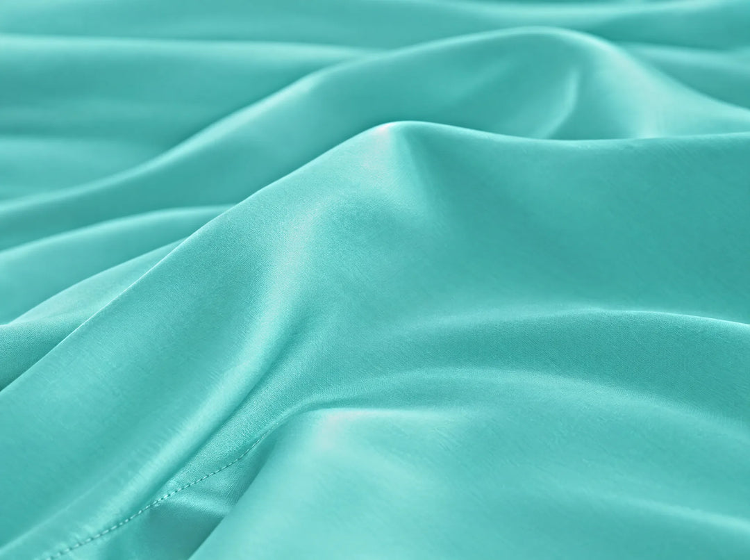 Tiffany Blue bamboo viscose flat sheet macro close-up of smooth silky sateen folds and a stitched hem
