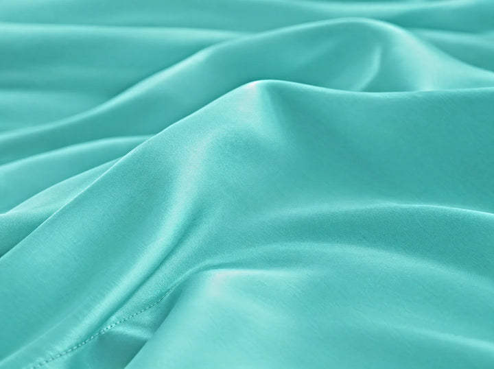 Tiffany Blue bamboo viscose flat sheet macro close-up of smooth silky sateen folds and a stitched hem