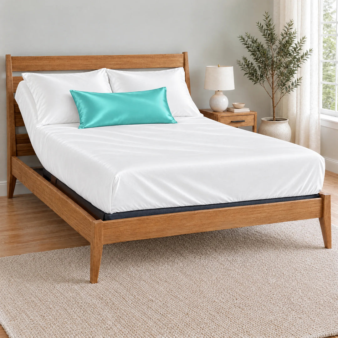 Tiffany Blue bamboo viscose sateen lumbar pillowcase on a made bed in front of white pillows in a light oak bedroom with an olive tree