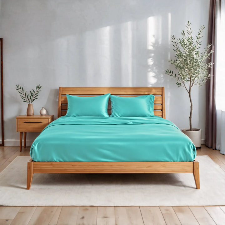 Tiffany Blue bamboo viscose sateen sheet set on a caramelized bamboo bed frame in a bright bedroom with a cream rug and olive tree
