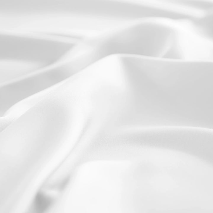 close-up of white bamboo bed sheets with sateen weave from the Signature Collection, highlighting silky texture and smooth drape