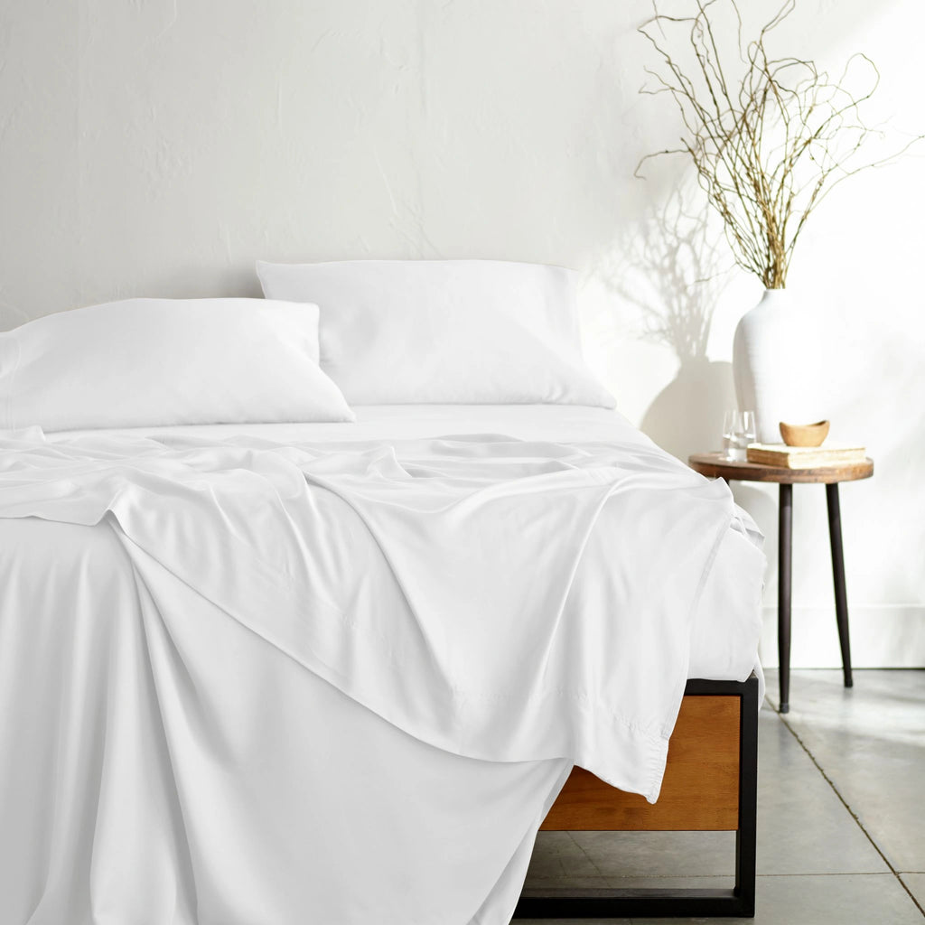 white bamboo bed sheets with sateen weave from the Signature Collection, shown from the foot of the bed with a draped flat sheet and matching pillowcases