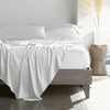 white bamboo bed sheets with sateen weave from the Signature Collection, shown from the foot of the bed with a draped flat sheet and matching pillowcases