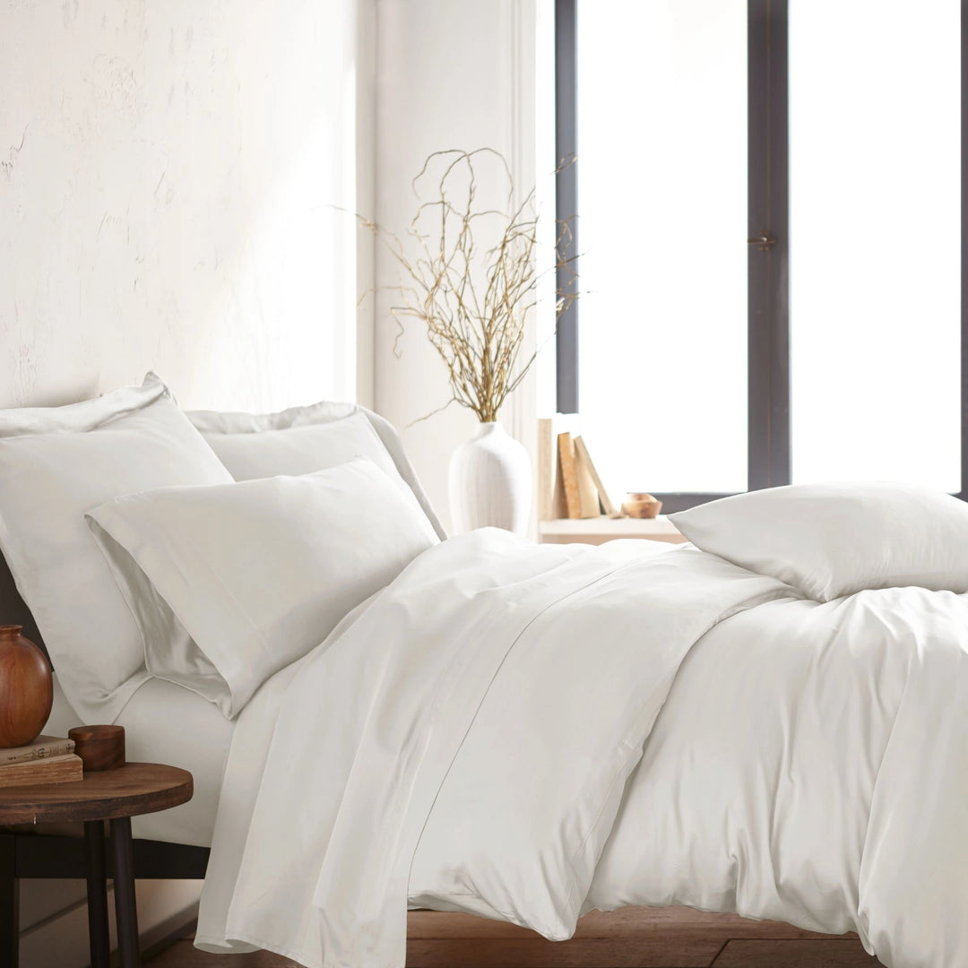modern bedroom with white bamboo sateen sheet set on king bed, featuring matching pillowcases and duvet, styled with natural light and minimal decor