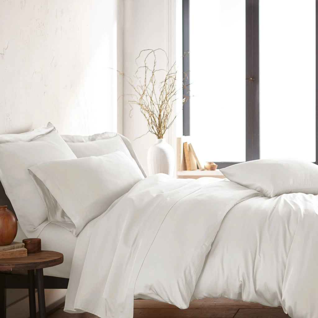 modern bedroom with white bamboo sateen sheet set on king bed, featuring matching pillowcases and duvet, styled with natural light and minimal decor
