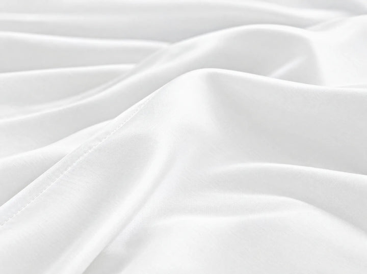 White bamboo viscose flat sheet macro close-up of smooth silky sateen folds and a stitched hem
