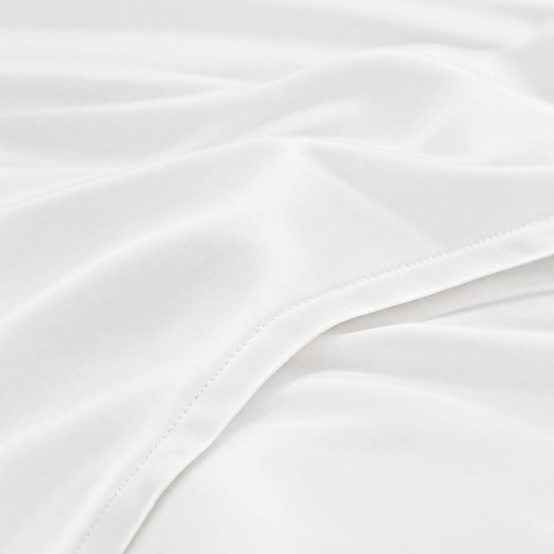 White bamboo viscose sateen lumbar pillowcase macro close-up of silky sateen folds and stitched hem