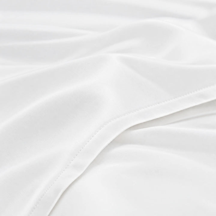 White bamboo viscose sateen lumbar pillowcase macro close-up of silky sateen folds and stitched hem
