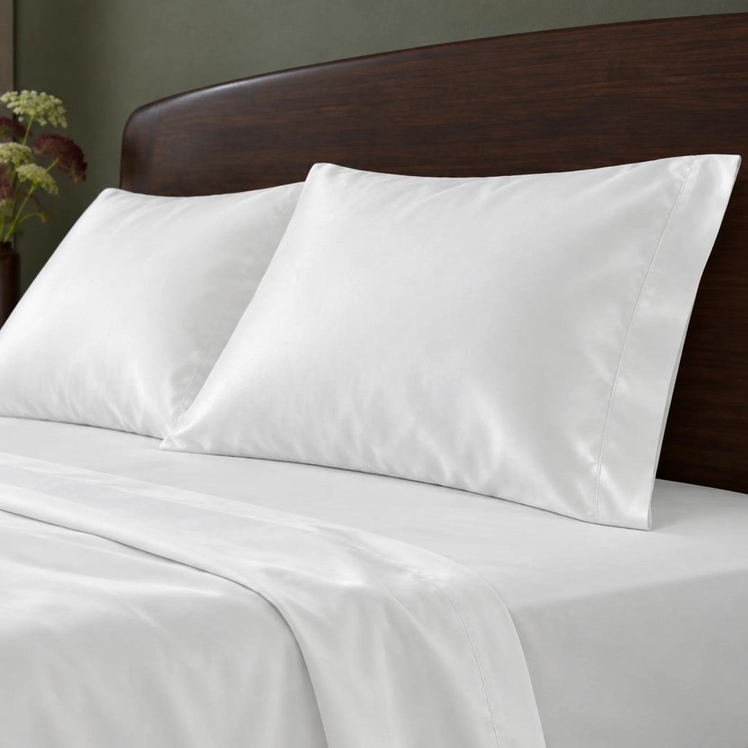 white bamboo viscose sateen pillowcases against a dark walnut headboard, showing the soft sateen sheen