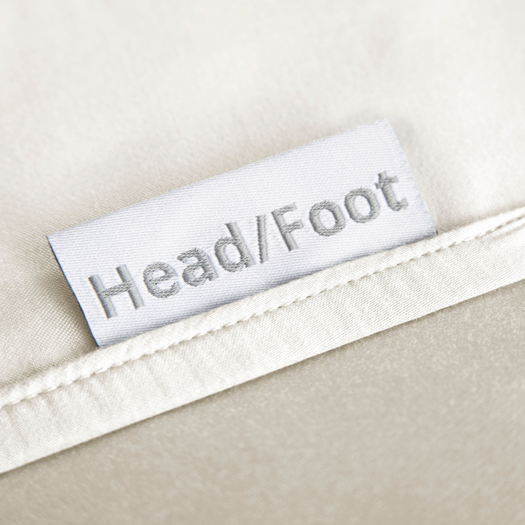 cream bamboo bed sheets with clearly labeled 'head' and 'foot' tags for easy bed-making