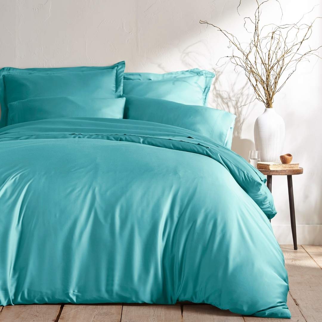 tiffany blue bamboo bed sheets with sateen weave from the Signature Collection, shown foot view with matching pillowcases and a modern nightstand